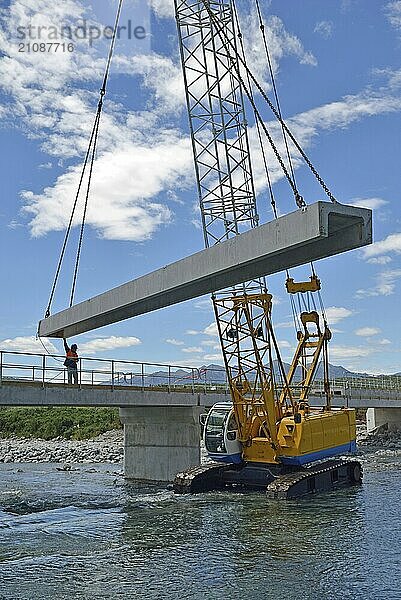 Builders construct a concrete bridge over a small river in Westland  New Zealand  Oceania