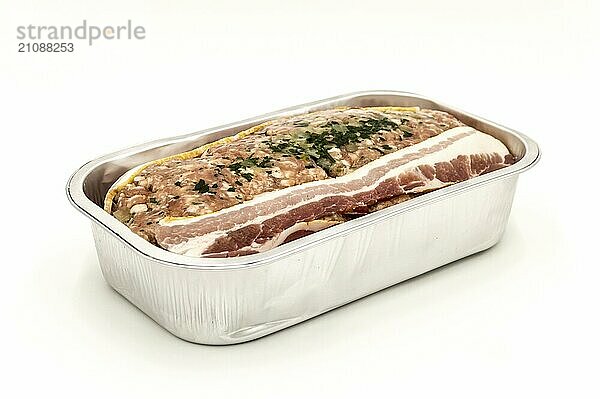 Meatloaf bereit  in seiner Aluminiumschale Profilansicht vor weißem Hintergrund zu backen