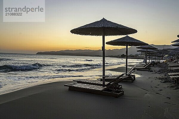 Sunbeds and umbrellas at sunrise on Stalis beach in northern Crete