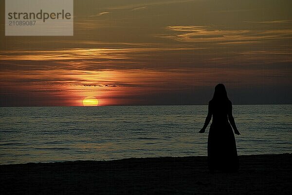 Silhouette einer Frau vor dem Sonnenuntergang am Strand in Ventspils  Lettland  Europa