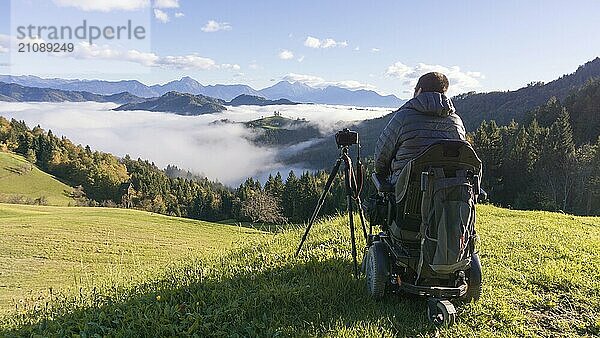 Mann im Rollstuhl macht Fotos von schöner Landschaft