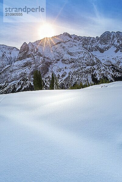 Ein schöner Wintertag in den österreichischen Alpen von der Gemeinde Ehrwald aus  mit felsigen Gipfeln und verschneiten Wiesen  die von einer hellen und bunten Sonne erwärmt werden