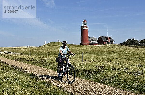 Frau  Seniorin mit Fahrrad am Leuchtturm Bovbjerg in Dänemark