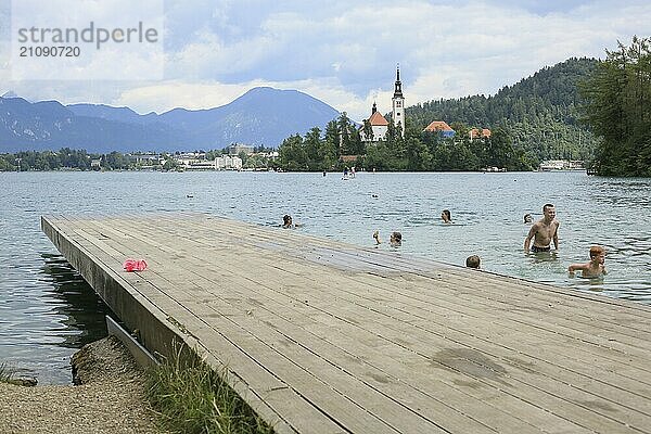 SLOWENIEN  BLED  15. JULI 2019: Schwimmen und Baden im Freien. Schöner Bergsee im Sommer mit kleiner Kirche auf Insel mit Alpen