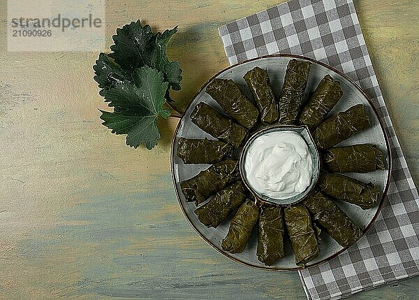 Dolma  Kohlrouladen in Traubenblättern  traditionelles armenisches Gericht  mit weißer Soße  Draufsicht  Nahaufnahme  selektiver Fokus