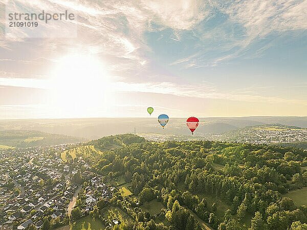 Heißluftballons schweben über eine hügelige und bewaldete Landschaft bei Sonnenuntergang  Calw  Schwarzwald  Deutschland  Europa