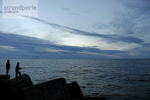 Silhouetten zweier Menschen bei Sonnenuntergang  Ventspils  Lettland  Europa