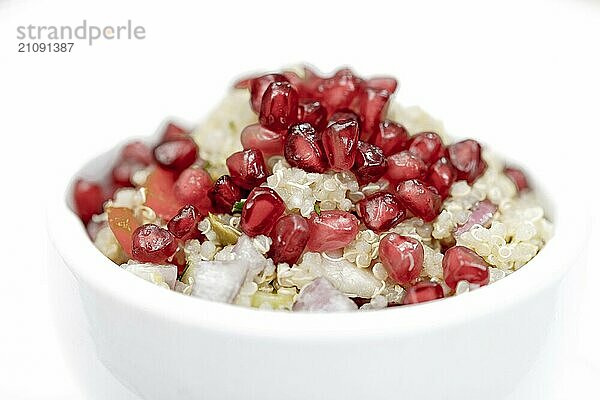 Quinoa Salat mit Granatapfelkernen  Radiccio  Gurke und Oliven auf weißem Hintergrund