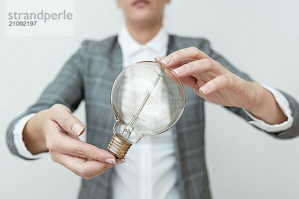 Lady Holding Lampe mit formalen Outfit präsentiert neue Ideen für Projekt  Business Frau zeigt Glühbirne mit zwei Händen ausstellen neue Technologien  Glühbirne präsentiert eine andere Openion