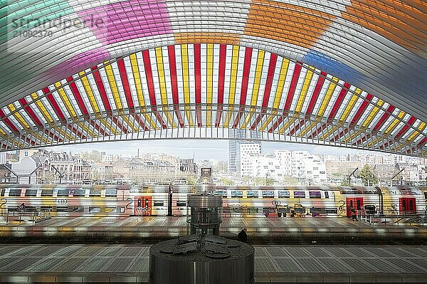 Bahnhof Liège-Guillemins  Architekt Santiago Calatrava  buntes Dach  Züge  Bahngleise mit zwei Personen  im Hintergrund Hochhäuser und andere Häuser  Lüttich  Belgien  Europa