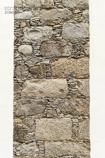 Vertikale Mauer aus Blaustein auf schwarzem Hintergrund mit Fugen  die mit Steinabfällen gefüllt sind