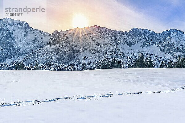 Schöne Winterlandschaft mit den schneebedeckten Bergen der österreichischen Alpen  der Baumgrenze und einem Weg aus Fußspuren im Schnee