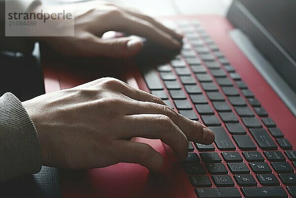 Seitenansicht Schuss der Hände des Mannes beschäftigt Arbeit an seinem Laptop sitzen am Holztisch