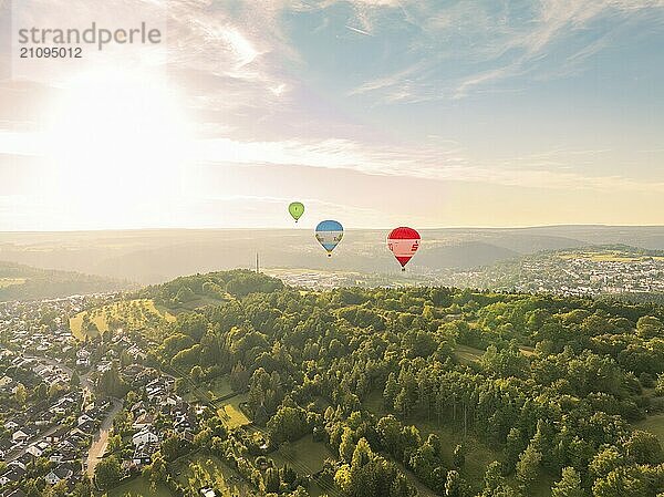 Blick auf mehrere Heißluftballons über einer bewaldeten Landschaft bei Sonnenuntergang nahe einer Stadt  Calw  Schwarzwald  Deutschland  Europa