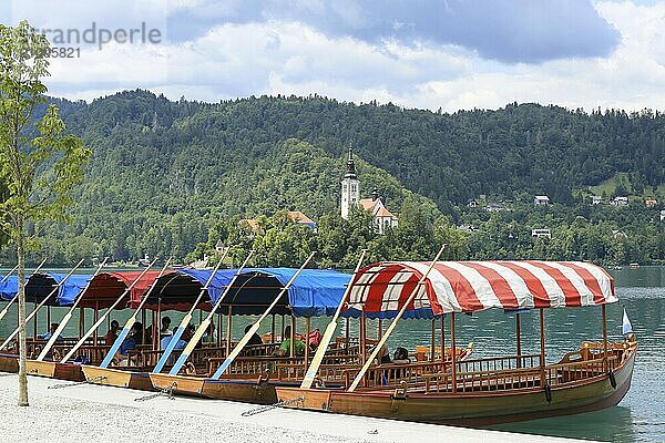 SLOWENIEN  BLED  15. JULI 2019: Traditionelle Seeboote. Schöner Bergsee im Sommer mit kleiner Kirche auf einer Insel und Alpen im Hintergrund