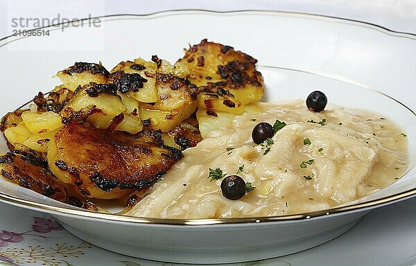 Schwäbische Küche  Saure Kutteln mit Röstkartoffeln  Kartoffelrädchen angebraten  Fleischgericht  Innereien  deftig  salzig  typisch Schwäbisch  Hausmannskost  Traditionsküche  Wacholder  Suppenteller  Foodfotografie  Studio  Deutschland  Europa