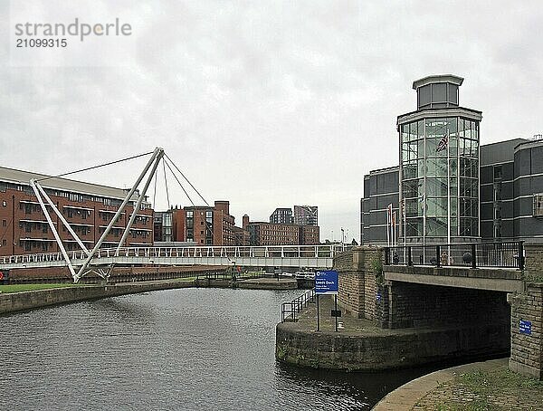 Leeds  west yorkshire  united kingdom  4 july 2019: knights bridge crossing the river aire and canal in leeds with waterside apartments and the royal armouries museum next to the dick entrance