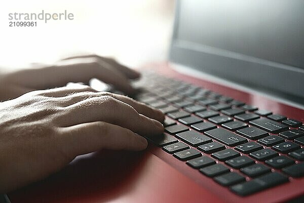 Seitenansicht Schuss der Hände des Mannes beschäftigt Arbeit an seinem Laptop sitzen am Holztisch