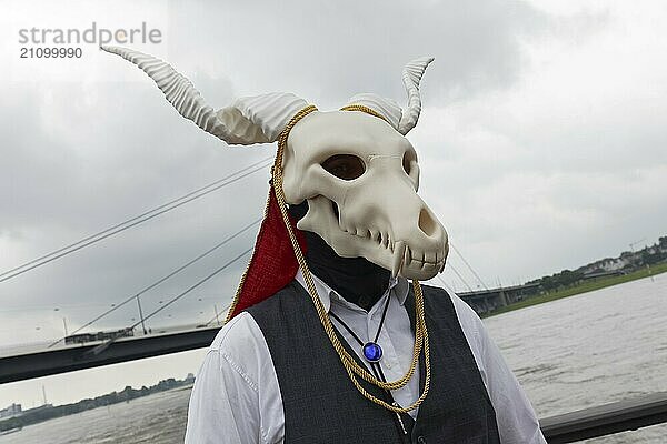 Kostümierter Mann trägt gruslige Maske  Schädel mit Schraubenhörnern  Cosplay beim Japantag Düsseldorf  Düsseldorf  Nordrhein-Westfalen  Deutschland  Europa