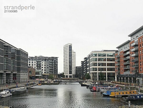 Leeds  west yorkshire  united kingdom  4 july 2019: a view of leeds dock from with houseboats moored next to waterside buildings