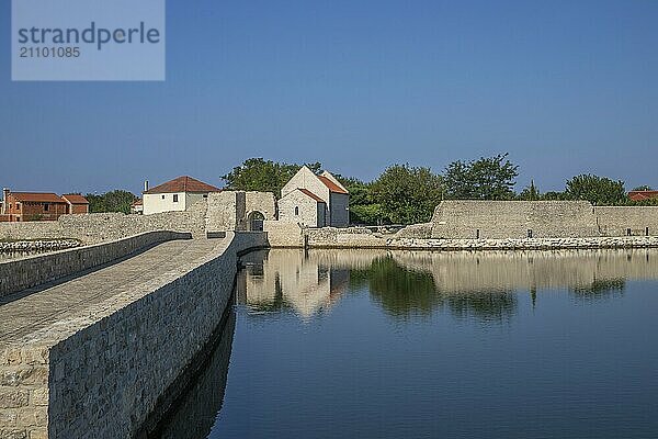 Skyline einer kleinen Mittelmeerstadt  historisches Stadtzentrum mit massiven Stadtmauern auf einer Insel in einer Bucht oder Lagune. Morgenstimmung in Nin  Zadar  Dalmatien  Kroatien  Adria  Europa