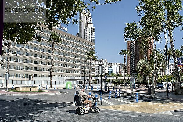 Mann kreuzt Zebrastreifen auf Elektroscooter vor einem Hotel in Benidorm  Provinz Alicante  Spanien  Europa