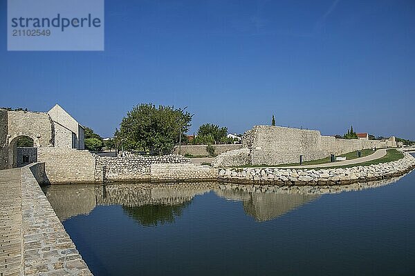 Skyline einer kleinen Mittelmeerstadt  historisches Stadtzentrum mit massiven Stadtmauern auf einer Insel in einer Bucht oder Lagune. Morgenstimmung in Nin  Zadar  Dalmatien  Kroatien  Adria  Europa