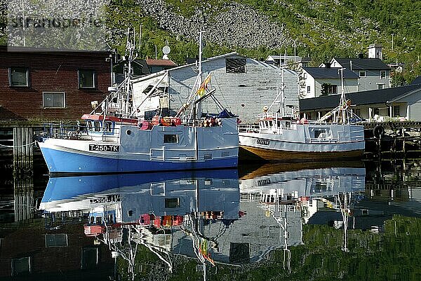 Fishing boats reflected in the Gryllefjord  Senja  Troms  Norway  Europe