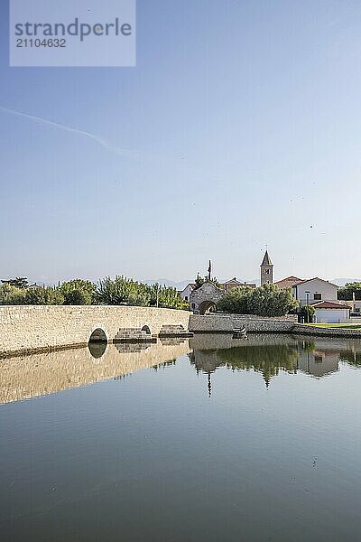 Skyline einer kleinen Mittelmeerstadt  historisches Stadtzentrum mit massiven Stadtmauern auf einer Insel in einer Bucht oder Lagune. Morgenstimmung in Nin  Zadar  Dalmatien  Kroatien  Adria  Europa