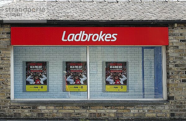 Brighouse  west yorkshire  united kingdom  21 july 2021: sign and front window display of a ladbrokes betting shop in brighouse west yorkshire