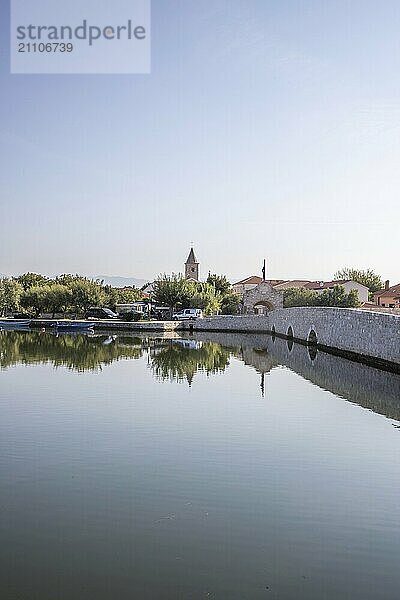 Skyline einer kleinen Mittelmeerstadt  historisches Stadtzentrum mit massiven Stadtmauern auf einer Insel in einer Bucht oder Lagune. Morgenstimmung in Nin  Zadar  Dalmatien  Kroatien  Adria  Europa