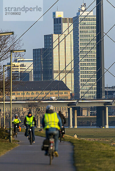 Düsseldorf  Skyline der Innenstadt  Hochhäuser  Rheinkniebrücke  Rhein  Radfahrer auf dem Rheinuferweg in Düsseldorf Oberkassel