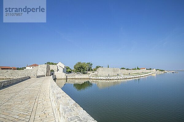 Skyline einer kleinen Mittelmeerstadt  historisches Stadtzentrum mit massiven Stadtmauern auf einer Insel in einer Bucht oder Lagune. Morgenstimmung in Nin  Zadar  Dalmatien  Kroatien  Adria  Europa