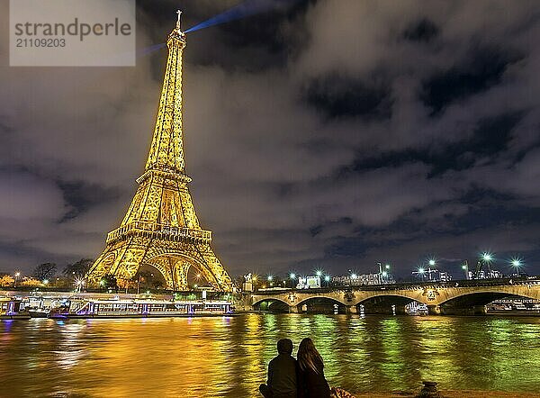 Paris  Frankreich  Februar 14  2016: Der Eiffelturm erleuchtet  die Seine und die Silhouette von zwei Liebenden in Paris  Frankreich am 14. Februar 2016  Europa