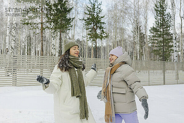 Happy women in warm clothes having fun on snow