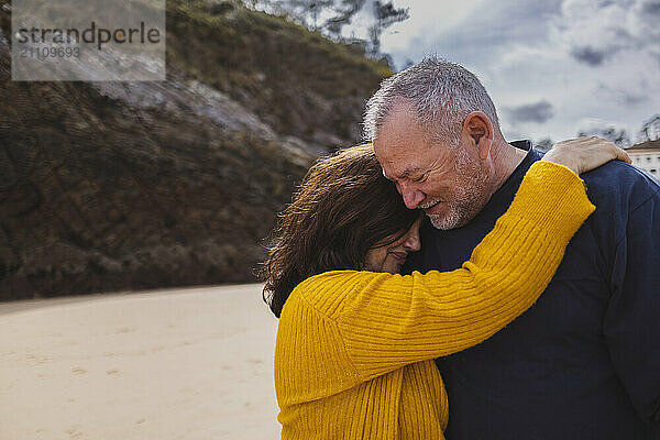 Senior woman embracing man at beach