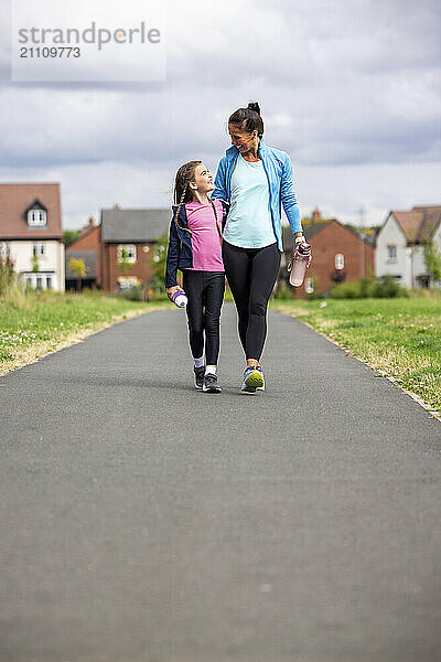 Daughter walking with mother on footpath