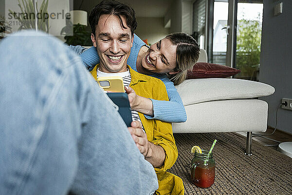 Happy couple using wireless technologies at home