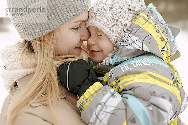 Affectionate mother and son in warm clothing during winter