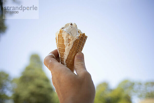 Hand of man holding melting ice cream