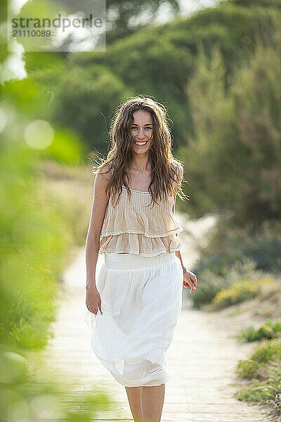 Beautiful woman with long hair walking on footpath