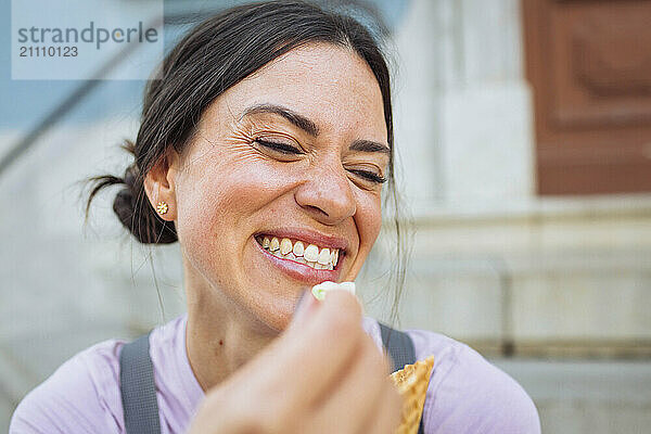 Happy young woman having ice cream cone