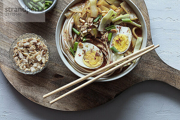 White cabbage soup with miso and udon noodles and boiled eggs and peanuts as topping