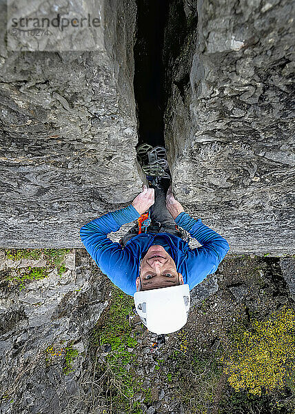 Determined rock climber climbing cliff