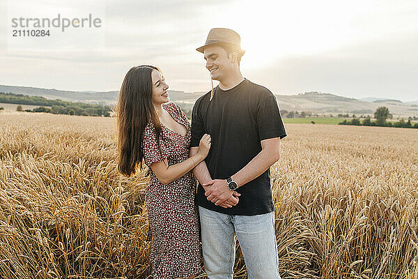 Playful young couple standing in agricultural field