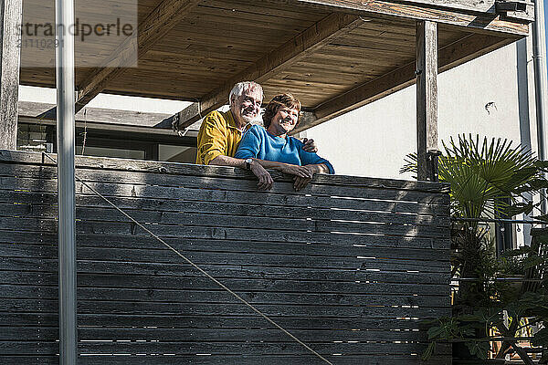 Happy senior couple near balcony in house