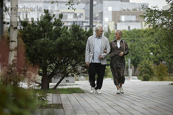 Senior couple with arm in arm walking on street