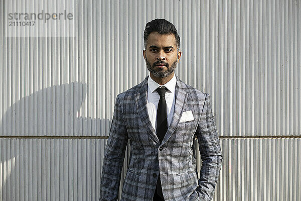 Businessman in suit standing in front of wall