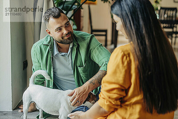 Husband and wife sitting with dog at home