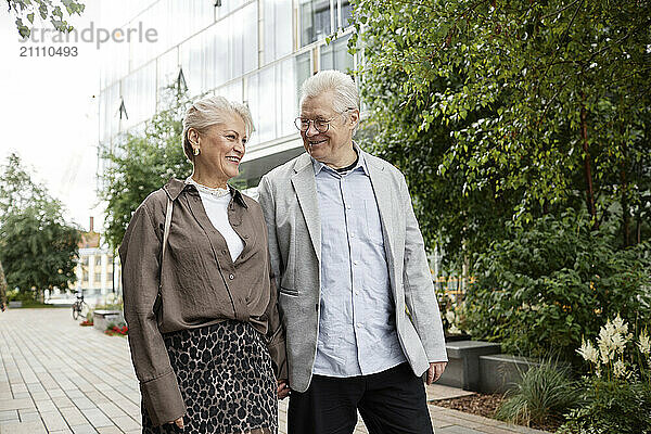 Happy man and woman walking on street